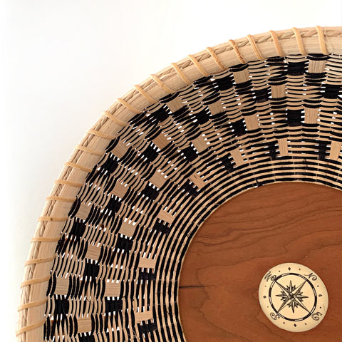 Detail of Round basket with natural and black pattern and cherry wood bottom with compass in the center by Susan Tyler at Cottage Curator - Sperryville VA Art Gallery