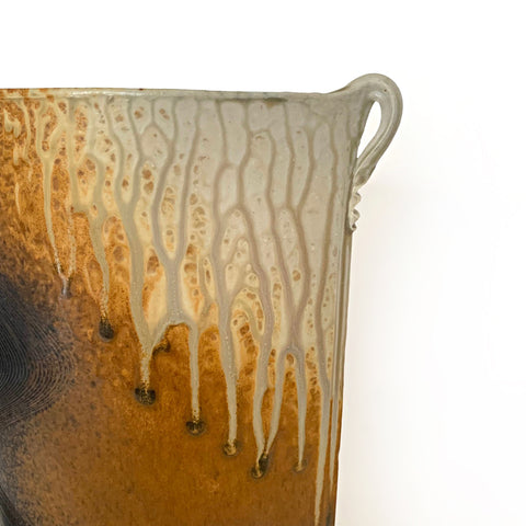 Detail of upper right handle on oval shaped ceramic vessel with two small handles at the top on either side and ochre, white and charcoal colored wood ash glaze by Richard Aerni at Cottage Curator - Sperryville VA Art Gallery