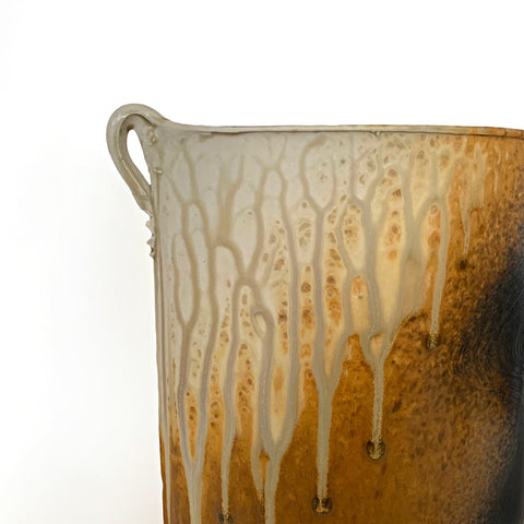 Detail of upper left handle on Oval shaped ceramic vessel with two small handles at the top on either side and ochre, white and charcoal colored wood ash glaze by Richard Aerni at Cottage Curator - Sperryville VA Art Gallery