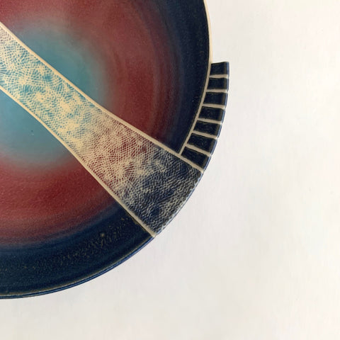 Detail of tapered porcelain bowl with spiral, symmetrical center design glazed in blue, red and green with ivory carving across the center by Wayne Bates at Cottage Curator - Sperryville VA Art Gallery