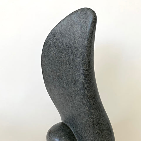 Detail view of gray soapstone sculpture with black base in the shape of a large rounded feather or wing by Robert Bouquet at Cottage Curator - Sperryville VA Art Gallery