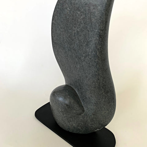 Detail view of gray soapstone sculpture with black base in the shape of a large rounded feather or wing by Robert Bouquet at Cottage Curator - Sperryville VA Art Gallery