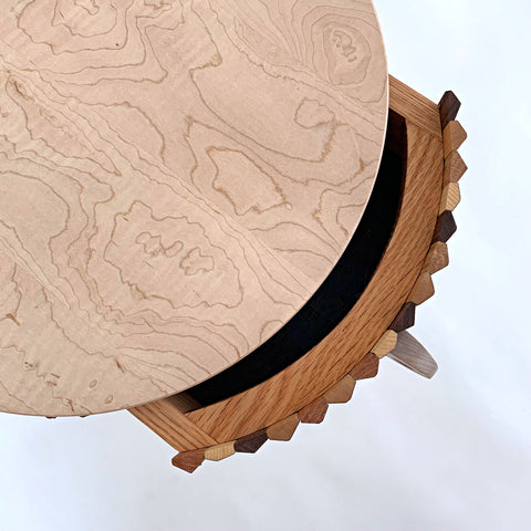Top view of round, three-legged table with drawer, circular handle in maple, oak, and cherry with milkpainted, multi-colored vertical stripes around outside edge by Christina Boy at Cottage Curator - Sperryville VA Art Gallery