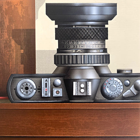 Detail of a camera with lens facing up in a painting by James Carter at Cottage Curator - Sperryville VA Art Gallery