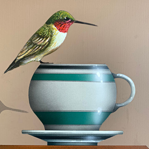 Detail of painting of Ruby-throated hummingbird perched on a teapcup sitting atop a box and stack of books, one called Homeward by James Carter at Cottage Curator - Sperryville VA Art Gallery