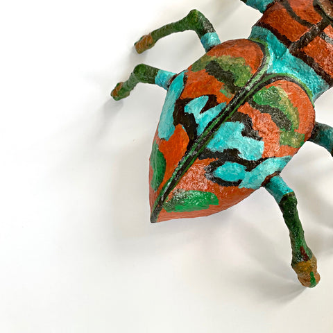 Beetle sculpture made with mixed media in black, green blue and orange by Joan Danziger at Cottage Curator Art Gallery - Sperryville Virginia