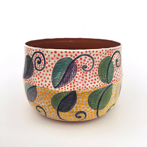 Ceramic bowl with two bands of leaf patterns with red polka dots on the top band and yellow on the bottom band by Sara Schneidman at Cottage Curator - Sperryville VA Art Gallery