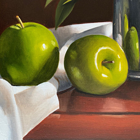 Detail of green apples from still life of pink peonies in a pewter mug on a tabletop with white cloth against a reddish-brown background by Liisa Strandman-Long at Cottage Curator - Sperryville VA Art Gallery