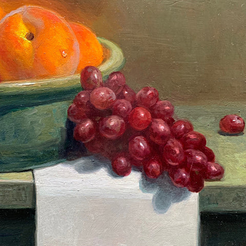 Detail of Still life painting of a bowl of golden peaches with red grapes on a tabletop by Vivian Tanga at Cottage Curator - Sperryville VA Art Gallery