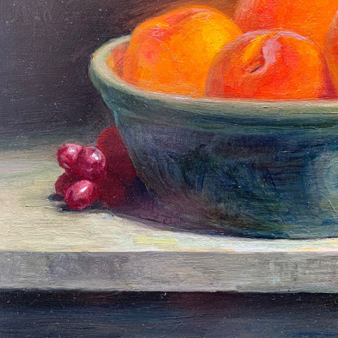 Detail of Still life painting of a bowl of golden peaches with red grapes on a tabletop by Vivian Tanga at Cottage Curator - Sperryville VA Art Gallery